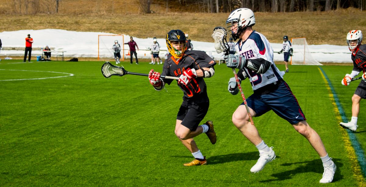 Two lacrosse players on a pitch