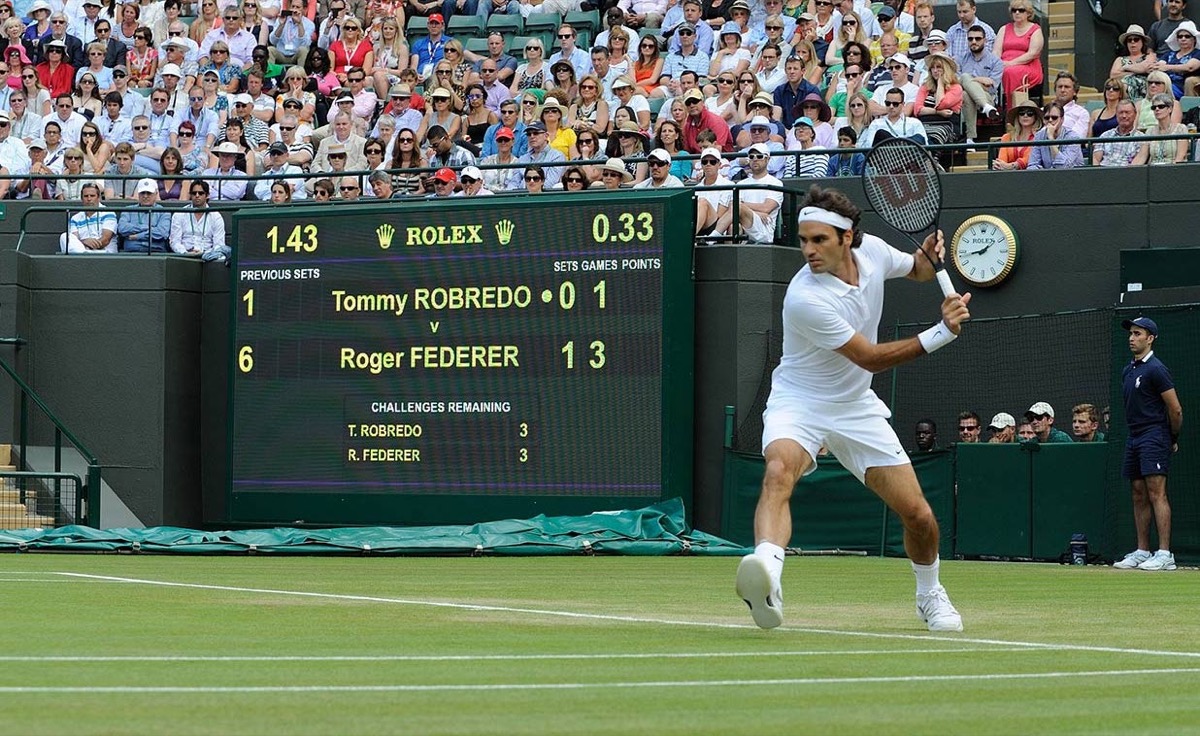 Roger Federer beside a tennis scoreboard in Wimbledon